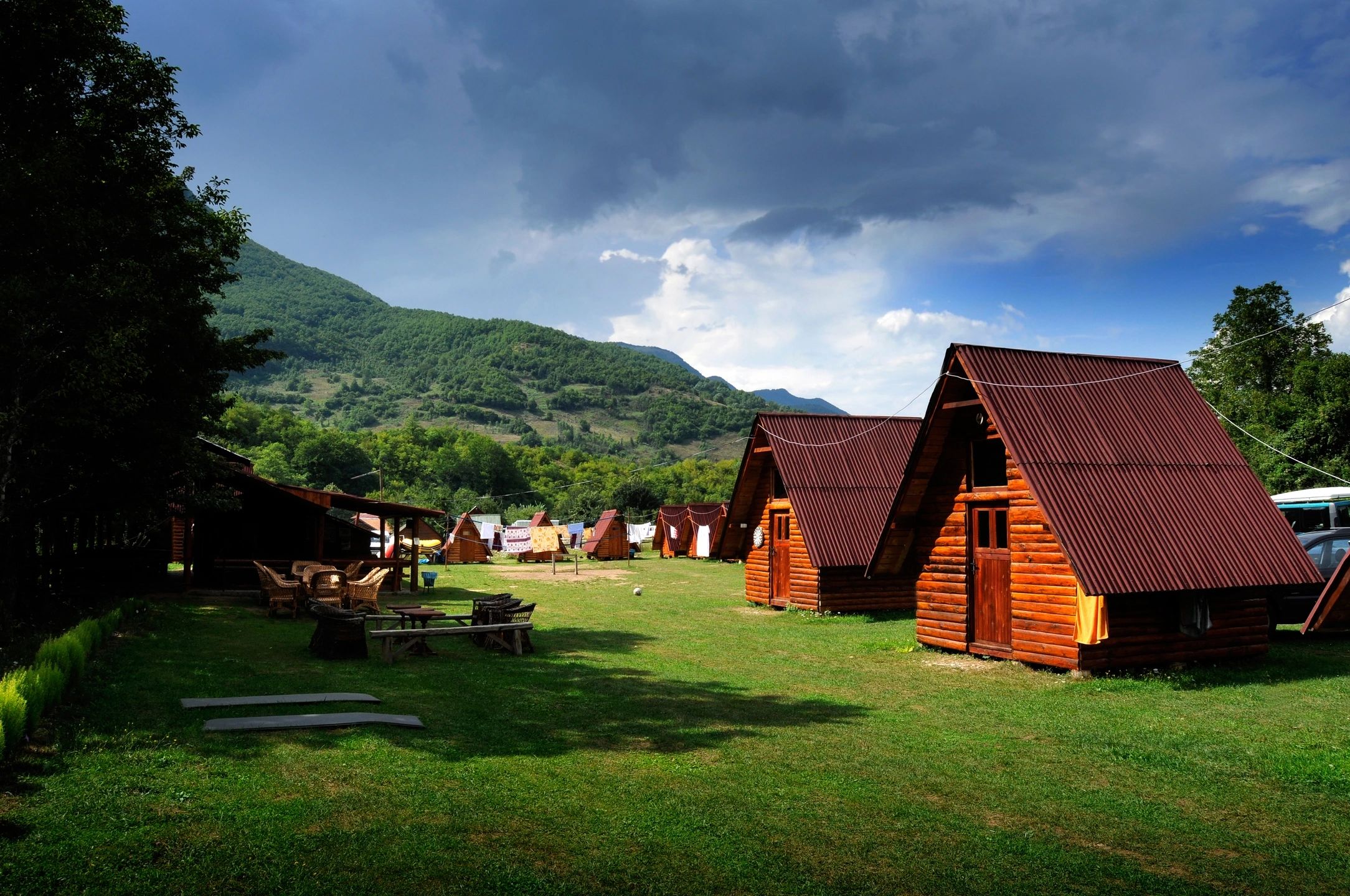 Wooden guest cottages on a green lawn
